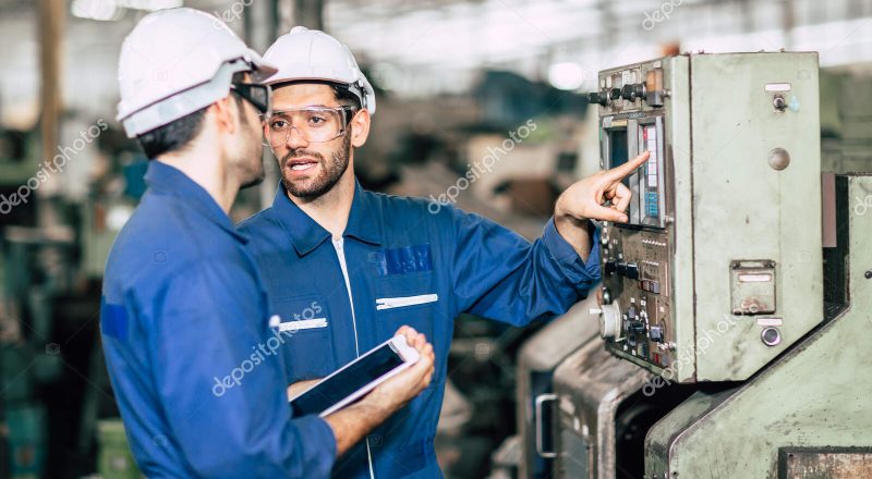 engineer teamwork checking control panel and teaching new worker to operating control the machine in factory.